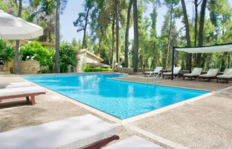 Swimming pool and surrounding space with umbrellas and sunbeds in Sani Cape Villas